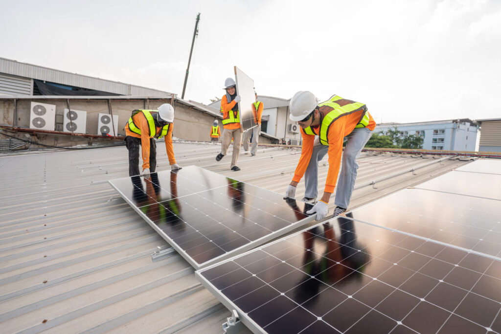 trabajadores instalando placas solares en un tejado gracias a subvención placas solares Andalucía
