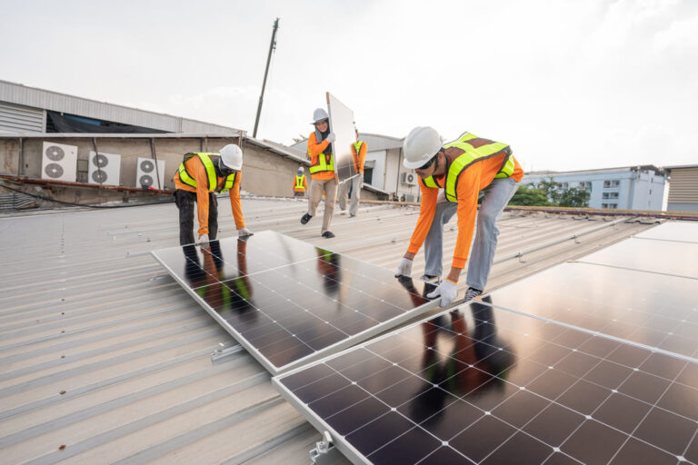 trabajadores instalando placas solares en un tejado gracias a subvención placas solares Andalucía